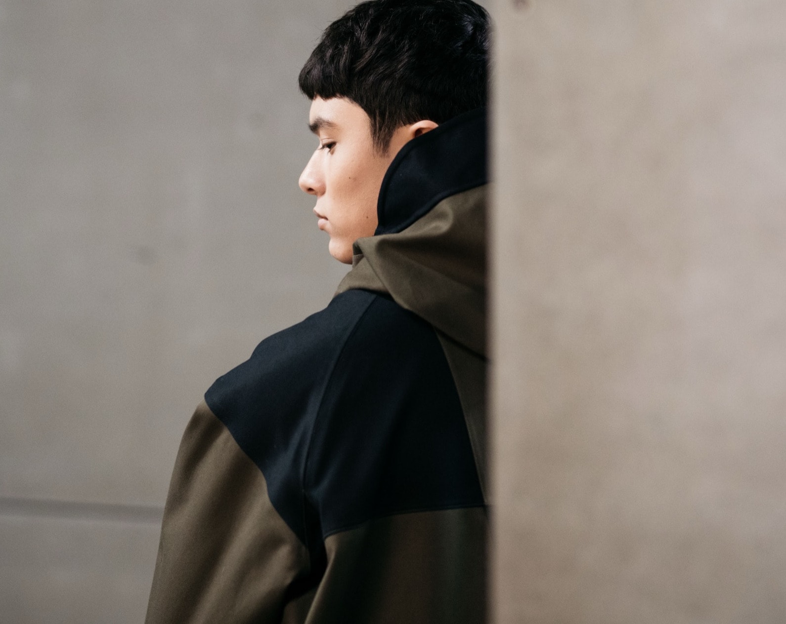 A founder in profile against a concrete wall