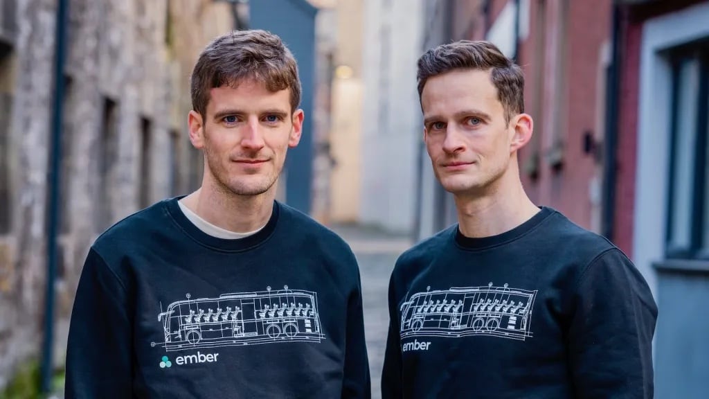 Ember's founders in matching sweatshirts printed with a bus schematic