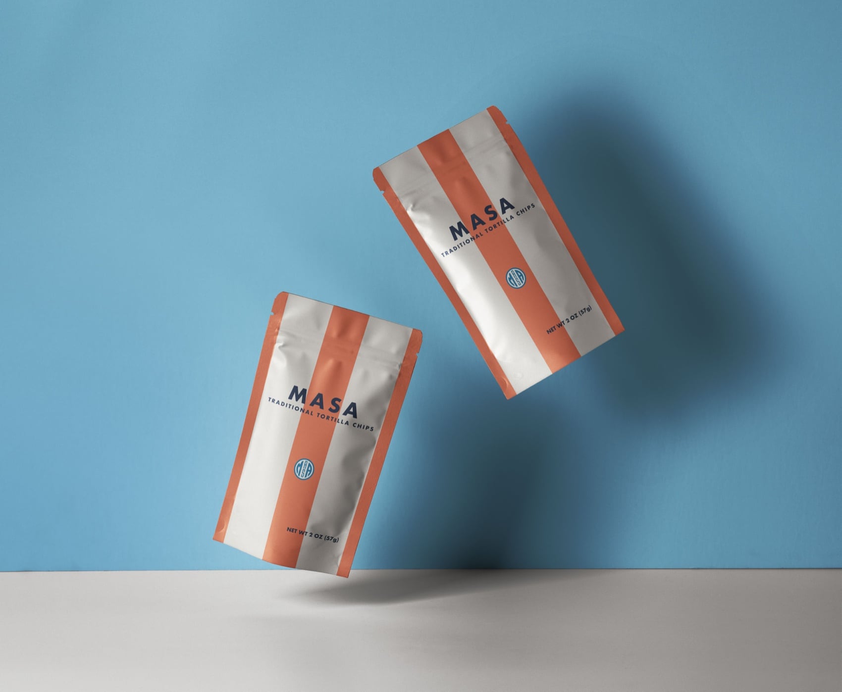 Two striped MASA tortilla chip bags floating against a blue wall